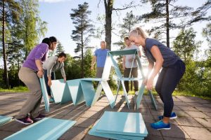 teambuilding Des collègues de travail font une pyramide avec des planches bleues sur le patio